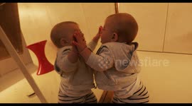 adorable baby kisses herself in a mirror