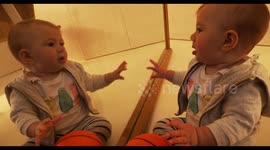 funny adorable baby kisses herself in a mirror