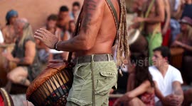 hippy drummers play on benirras beach during the summer in ibiza, spain