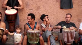 hippy drummers play on benirras beach during the summer in ibiza, spain