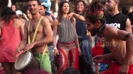 hippy drummers play on benirras beach during the summer in ibiza, spain