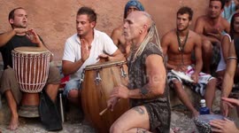 hippy drummers play on benirras beach during the summer in ibiza, spain