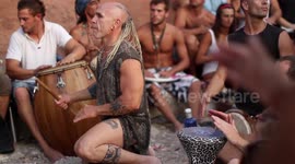hippy drummers play on benirras beach during the summer in ibiza, spain