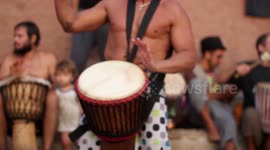 hippy drummers play on benirras beach during the summer in ibiza, spain