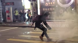 Hong Kong protesters extinguish tear gas fired by police in Wan Chai
