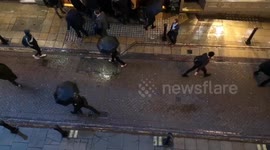 Londoners try to escape rain with umbrellas
