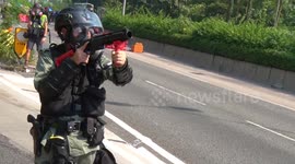 Police in Hong Kong march down street firing tear gas at protesters