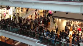 HK protesters singing their anthem, waving the Stars and Stripes and their own flag in a shopping mall.