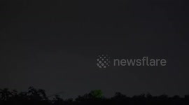 An airplane flies into a dramatic lightning storm sky over Pathumthani Thailand. (closeup version #3).