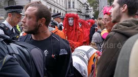Red Brigade protesters walk between Extinction Rebellion and Police
