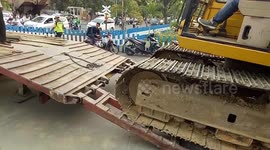 The Difficult Struggle of Excavators to Ride a Transport Truck