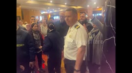 Ship crew tries to calm passengers as they chant angry about conditions on ship and missed ports