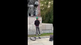 German painting a swastika on the Soviet War Memorial Treptow, Berlin