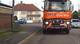 Driver of cement mixer lorry with no wing mirror uses phone to reverse down UK road