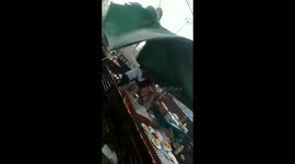 Storm winds nearly blow away street vendor's stall in western Indonesia