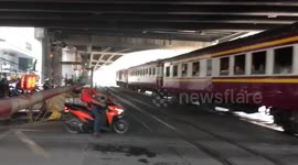 Impatient Thai motorcyclist clotheslined by level crossing barrier