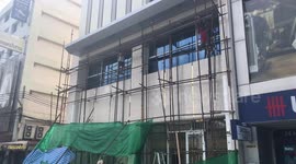 Builders In Flip-Flops Work On Scaffolding