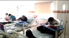 Student doctors infected with dengue take medical exam with drips in their hands at hospital in Jamnagar, India