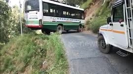 Bus driver takes nail-biting U-turn beside cliff face on narrow hilly road in northern India