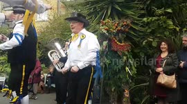 Quaint English folk procession with traditional characters takes place in London for harvest festival..