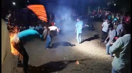 Youths in west India dance, eat and lash themselves with fire for festival