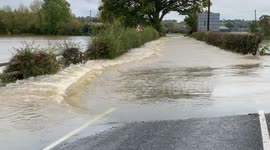 Floodwaters cascade across road leading to Mid-Wales airport