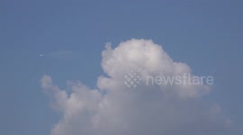 Two airplanes in a blue sky with white clouds.