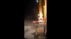 The brave chicken sitting in front of the excavator moving on the road to hitchhike