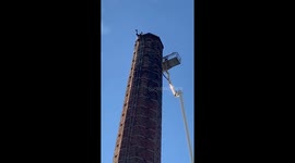 Massive cherry picker arrives to rescue man hanging upside down from 290ft chimney in England