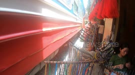 Cafes and shops set up on train tracks shift for passing locomotives in Hanoi
