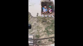 Father of two uses excavator to carry his children across floodwater in Vietnam