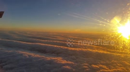 Flying over a sea of white clouds at sunrise.
