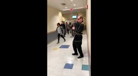 High school math teacher playing saxophone in costume for students passing in the hall