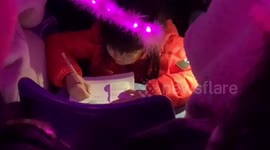 Chinese girl does her homework at Taiwanese superstar's concert