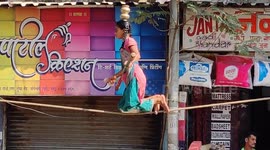 Teenaged girl putting up a show displaying her balance skills on a single rope in Mumbai