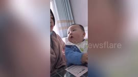 Chinese mother stops chewing when her son looks at her to avoid being caught eating