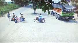 Four riders stumble to the ground after their scooters collide on road in rural India