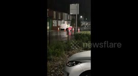 TRAFFIC OFFICER DIVERTING TRAFFING IN THE RAIN