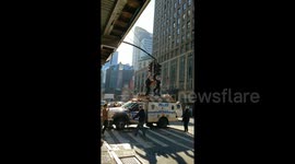 New York City police remove man sitting on top of traffic lights