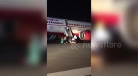 Dramatic moment passengers slide out using bloated raft after flight makes emergency landing in central India