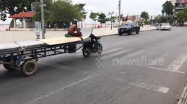 Terrifying moment woman rides on cargo of motorcycle trailer