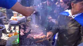 Greek nationalists hold pork barbecue close to refugee camp