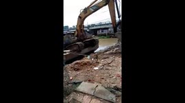 Amazing video shows excavator operator cleverly lifting his machine onto boat in Vietnam