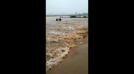 Locals rescue man and his motorbike who were swept away by flash flooding in Vietnam