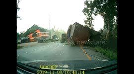 Articulated truck topples over after trying to avoid another overtaking truck in Thailand