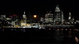 A near full-moon rises majestically behind St Paul's Cathedral and the City of London