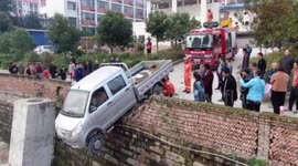 Firefighters save driver stuck inside truck hanging off 13ft-high wall