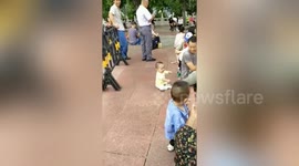 Chinese baby bum shuffles over to his father at park