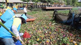 Cleaners paddle through mountains of waste left after Buddhist festival
