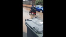 Lady on mobility scooter drivee through floods